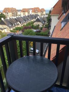 uma mesa preta numa varanda com vista para as casas em Appartement vue mer em Villers-sur-Mer