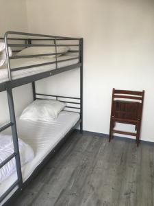 two bunk beds in a room with a chair at Appartement vue mer in Villers-sur-Mer