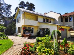 a yellow and white house with a patio at Apartments Elina Viktorijas Street in Jūrmala