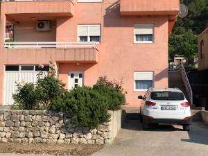 a white car parked in front of a building at Apartmani Milan in Trebinje
