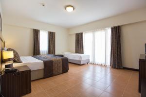Postel nebo postele na pokoji v ubytování The One Club Hotel