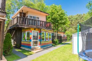 una casa colorata con balcone sopra di ZAKĄTEK ADELI a Mikoszewo
