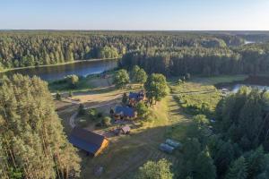 an aerial view of a house on a farm next to a lake at Ignalina Lux Villa in Ignalina
