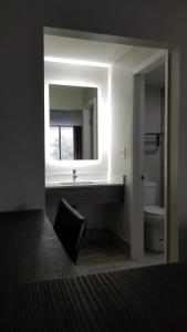 y baño con lavabo y espejo. en Days Inn & Suites by Wyndham Charleston Airport West, en Charleston