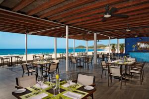 a restaurant on the beach with tables and chairs at Krystal Grand Los Cabos - All Inclusive in San José del Cabo