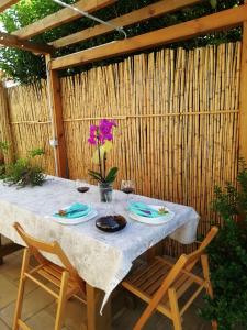 a table with plates and a vase of flowers on it at Appartamento Joanna in Nurachi