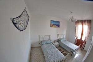 Cette chambre comprend 2 lits et un parasol sur le mur. dans l'établissement SALENTO DA INCANTO, à Spongano