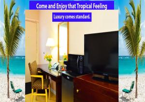 a hotel room with a desk with a television and a palm tree at Rockwell Resort in Niagara Falls