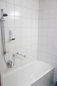 Das Bad ist mit einer Badewanne mit einer Dusche ausgestattet. in der Unterkunft Hotel Burgstallerhof in Feld am See