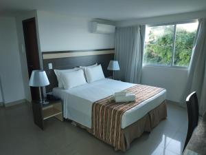1 dormitorio con cama y ventana en Val Atlantic Hotel en João Pessoa