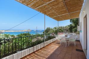 a balcony with a table and chairs and a view of the ocean at Aphrodite White Studios Lindos in Lindos