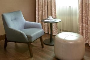 a chair and a stool with a cup on a table at Sofitel Philadelphia at Rittenhouse Square in Philadelphia
