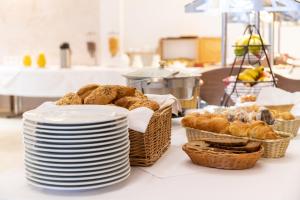 einen Tisch mit Brotkörben und Körben mit Gebäck in der Unterkunft Stadthotel Alsfeld in Alsfeld