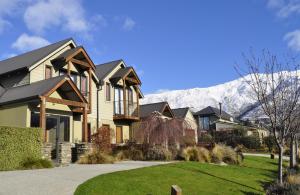 a house with a mountain in the background at Wanaka Luxury Apartments in Wanaka