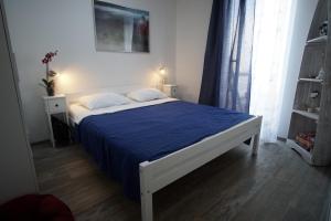 Un dormitorio con una cama grande con una manta azul. en Mary's Garden, en Tuliševica