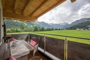 einen Balkon mit einem Tisch, Stühlen und Bergen in der Unterkunft Alpinjuwel in Hippach in Hippach