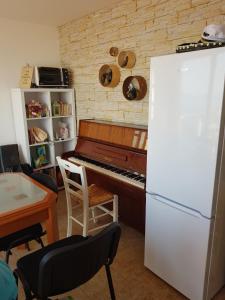 La cuisine est équipée d'un piano et d'un réfrigérateur blanc. dans l'établissement Mary's Garden, à Tuliševica