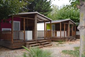 un chalet avec des marches en bois devant une maison dans l'établissement L'Oasis, à Grospierres