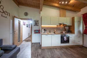 uma cozinha com armários brancos e uma sala de estar em Alpinjuwel in Hippach em Hippach