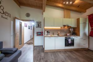 a kitchen with white cabinets and a living room at Alpinjuwel in Hippach in Hippach