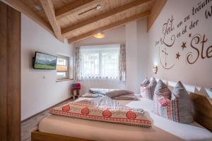 a bedroom with two beds and a tv on a wall at Alpinjuwel in Hippach in Hippach