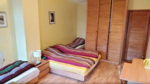 a room with two beds in a room with wooden floors at Iwona Hostel - Budget Rooms with Private Bathrooms in Sopot