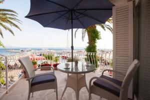 a table and chairs on a balcony with an umbrella at Boutique Waterfront Apartments in Podgora