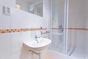 a white bathroom with a sink and a shower at Rodinný pension Bečov in Bečov nad Teplou +47 photos
