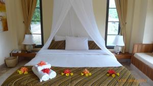 Un dormitorio con una cama con toallas y flores. en Villa Khao Phaengma, en Wang Nam Khiao