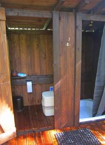a bathroom with a toilet in a wooden cabin at Tahkuna tree-house in Malvaste