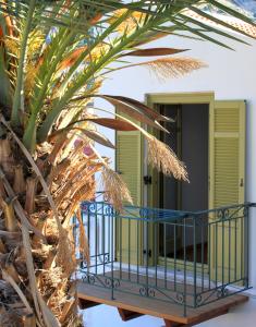 a house with a balcony and a palm tree at EVANNA HOUSE in Symi