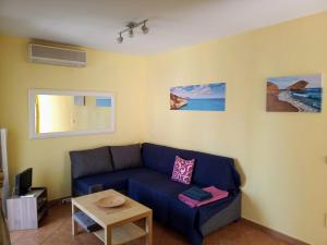 a living room with a blue couch and a table at apartamento Isleta del Moro, Cabo de Gata in La Isleta del Moro