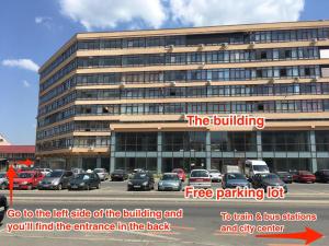 Un gran edificio con un estacionamiento enfrente. en CosmopolitApart, en Sibiu