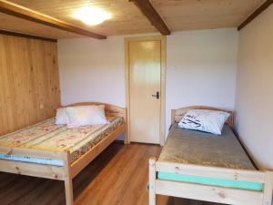 2 Betten in einem Zimmer mit Holzböden in der Unterkunft Pirmie Zaļmeži in Jūrkalne