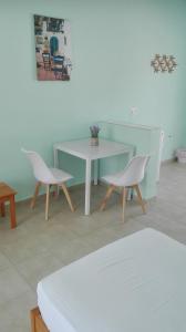 斯基亞索斯鎮的住宿－Alexandros Guest House，一间设有白色桌子和两把椅子的房间