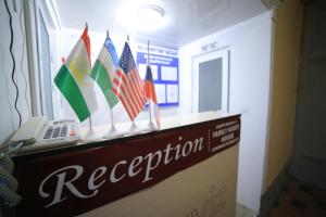 a reception desk with flags on top of it at PARVIZ GUEST HOUSE in Bukhara
