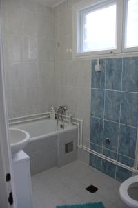 a bathroom with a tub and a toilet and a sink at Apartman KEJ in Pirot +32 photos