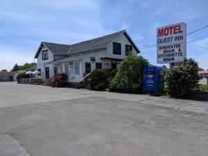 une maison avec un panneau de motel devant elle dans l'établissement Guest Inn Motel, à Trenton