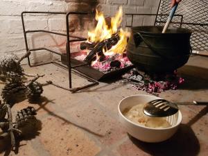 a pot and a bowl of food next to a fire at SONVANGER VILLA YZERFONTEIN in Yzerfontein