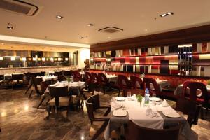 فندق مايا في شانديغار: مطعم بطاولات وكراسي وبار