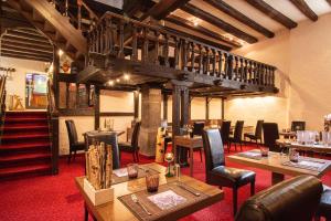 a restaurant with tables and chairs and a staircase at Boutique-Hotel Lohspeicher in Cochem