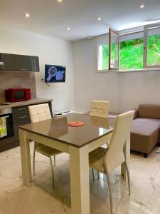 a kitchen and dining room with a table and chairs at LesJardinsFleuris in Mandelieu-La Napoule