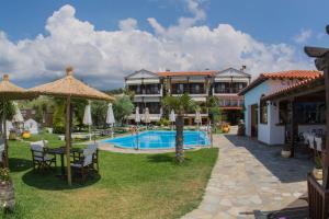 a resort with a swimming pool and a building at HOTEL BARA in Neos Marmaras