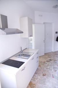 a white kitchen with a sink and a refrigerator at Clambè in Palermo