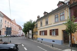 a street with a yellow building on the side of the road at Anne's House in Sibiu