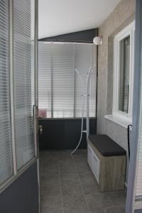 a bathroom with a shower with a bench and a window at Apartman KEJ in Pirot