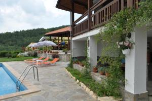 a house with a swimming pool next to a building at Guest House Brezata - Betula in Glavatartsi