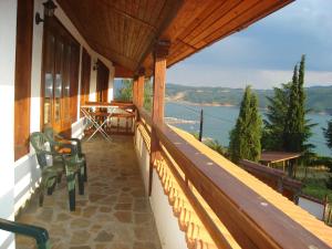 einen Balkon eines Hauses mit Blick auf das Wasser in der Unterkunft Guest House Brezata - Betula in Glavatartsi