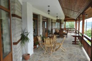 a porch with chairs and tables on a building at Guest House Brezata - Betula in Glavatartsi