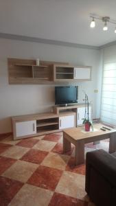 a living room with a tv and a coffee table at Apartamento Olivia in Nerja